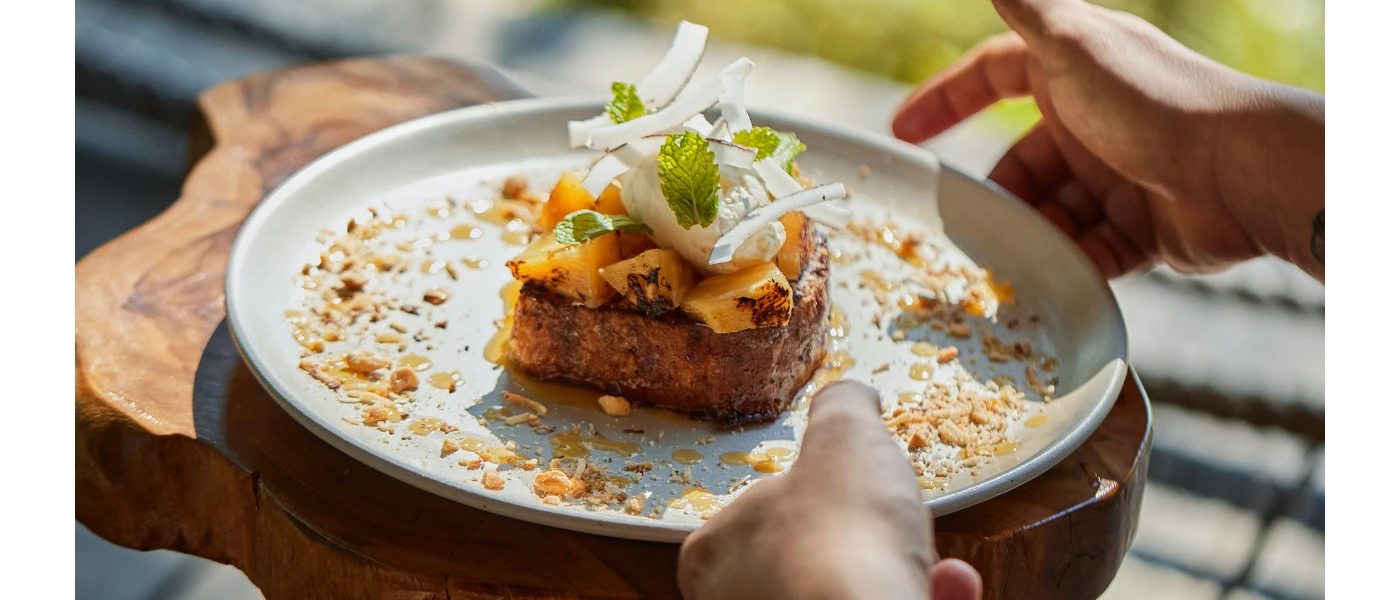 Nutritious looking stacked food on a white plate with a herb garnish