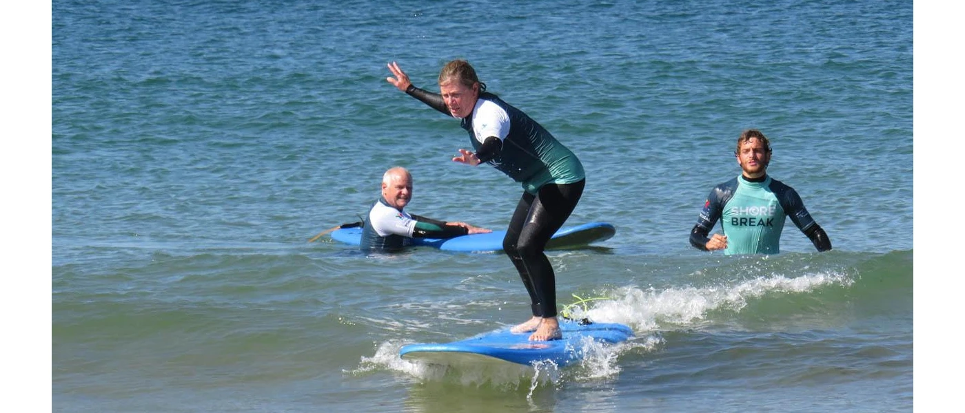Group in wet suits surf in the sea