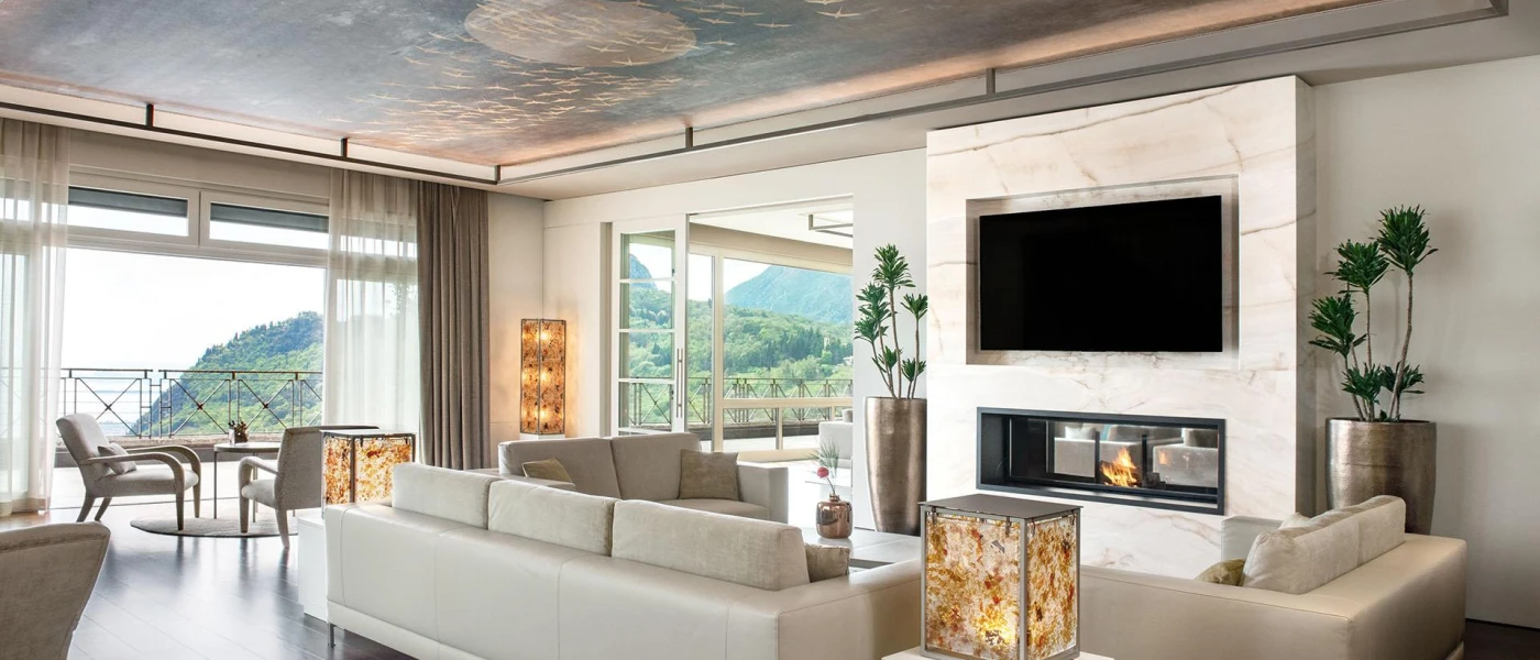 Suite living area with square lanterns, neutral soft furnishings and a TV hanging on the wall above a fireplace
