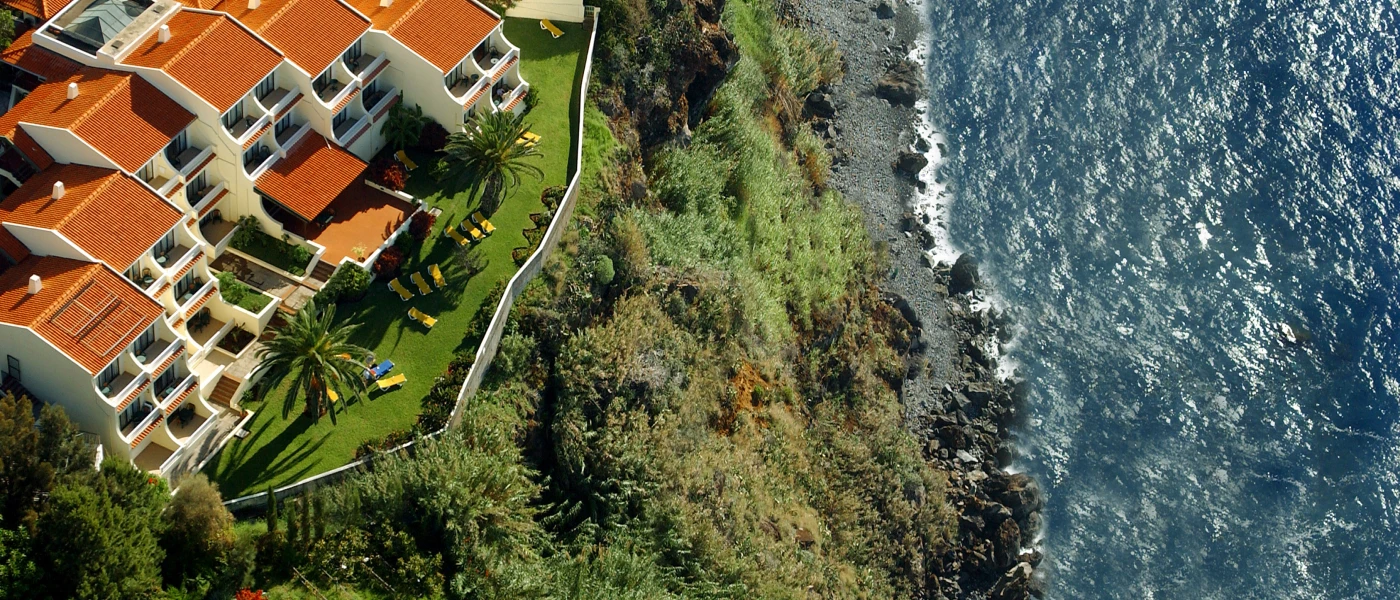 Terracotta-roofed resort on a green hilltop overlooking the Atlantic Ocean