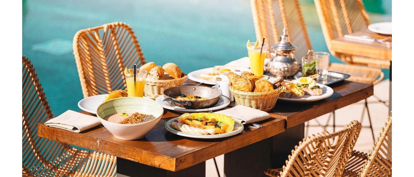 Table set up for breakfast with baskets of pastries and glasses of orange juice