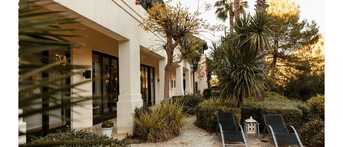 Tropical greenery surrounding a courtyard with black mesh loungers