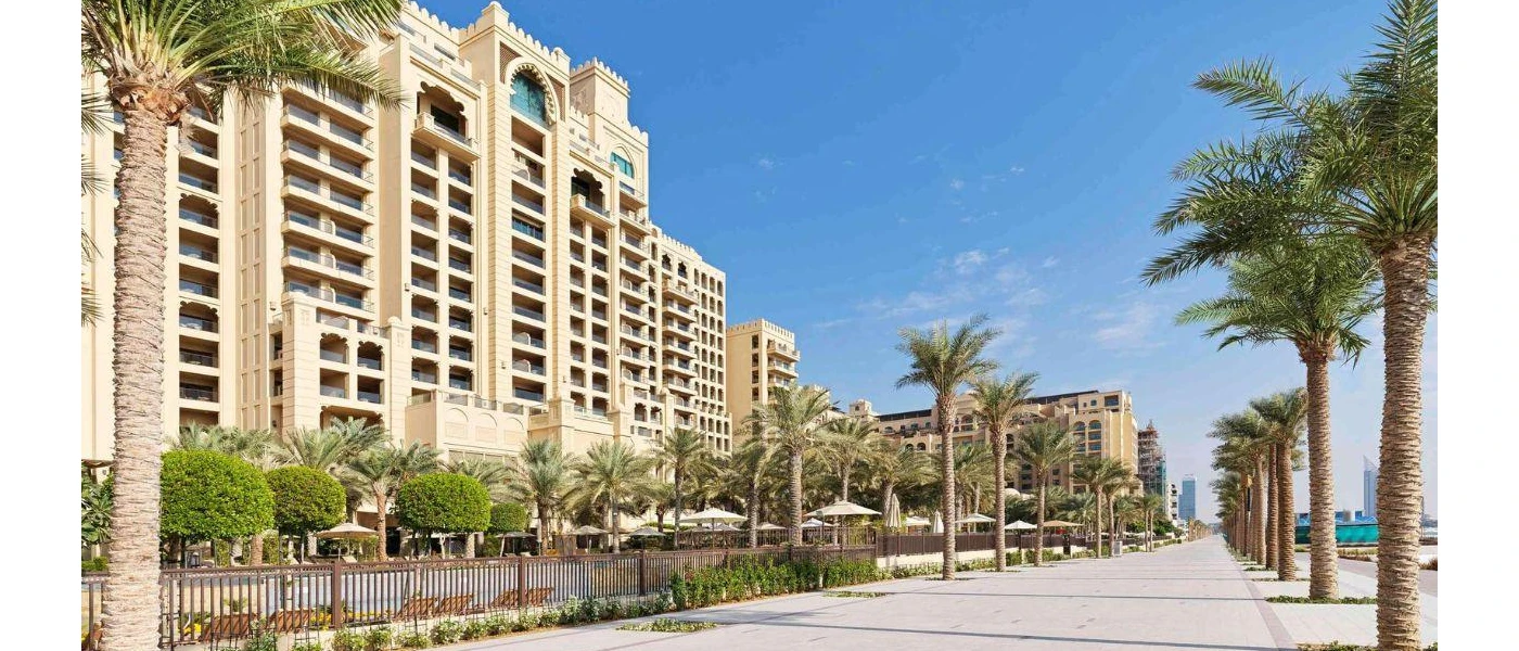 Palm-line promenade next to the palatial exterior of Fairmont The Palm