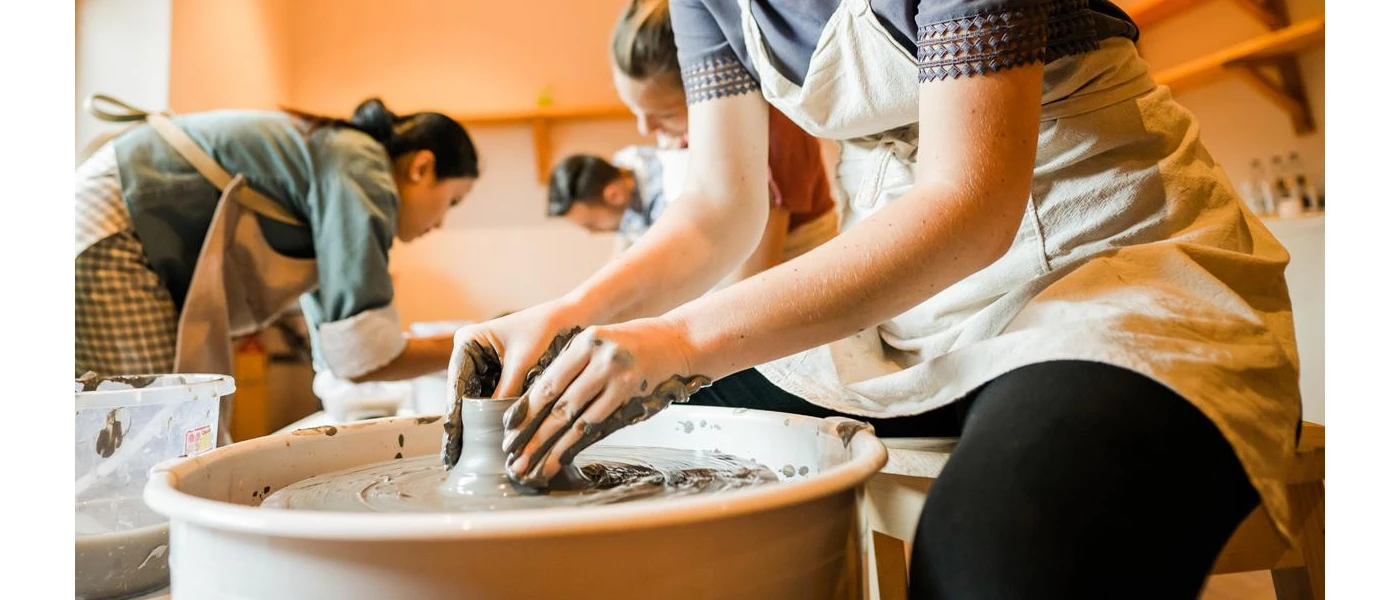 Group in aprons in a pottery class