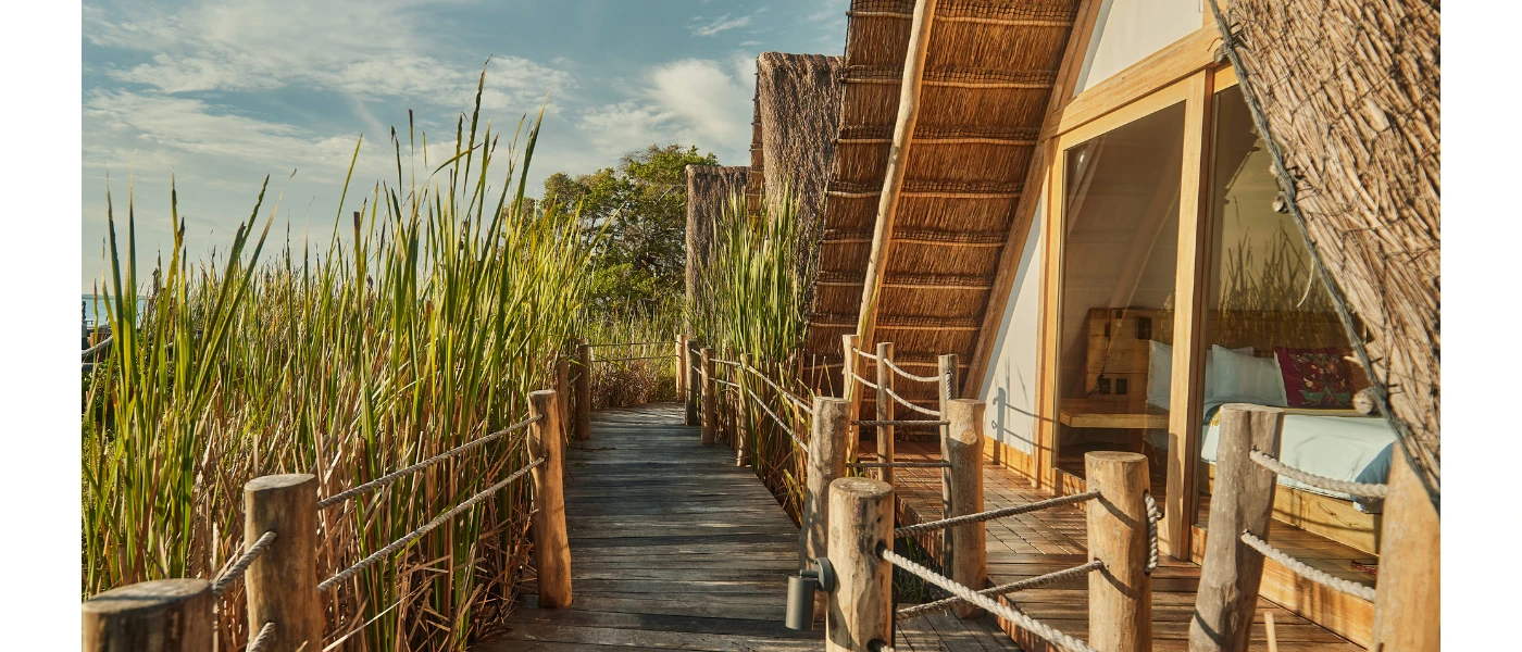 Thatched-roof accommodation with wooden decking among jungle greenery