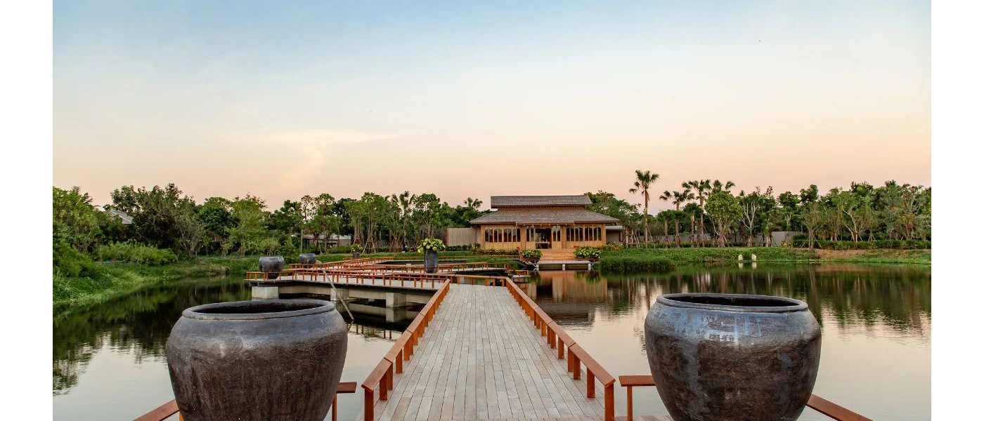 River jetty with wooden sides and paved flooring, and two big black pots at one end over a river