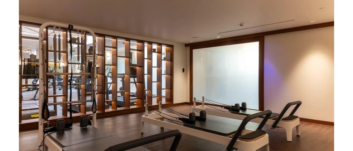 Reformer Pilates equipment in a chic studio with wooden furnishings and spotlights