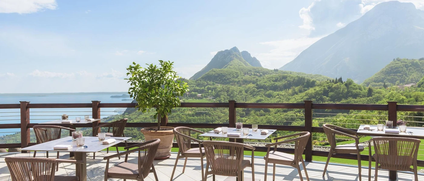 Outdoor wooden terrace with a lake view overlooking green peaks
