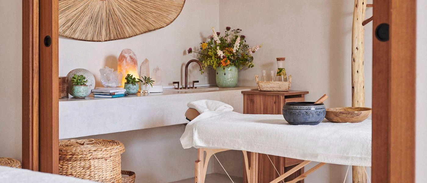 Boho-style room with a rattan wall hanging, candlelight, plants and a white table