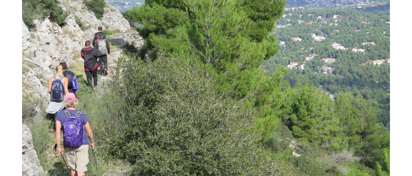 Group walking in a line along the rocky hilltops in the Greek countryside