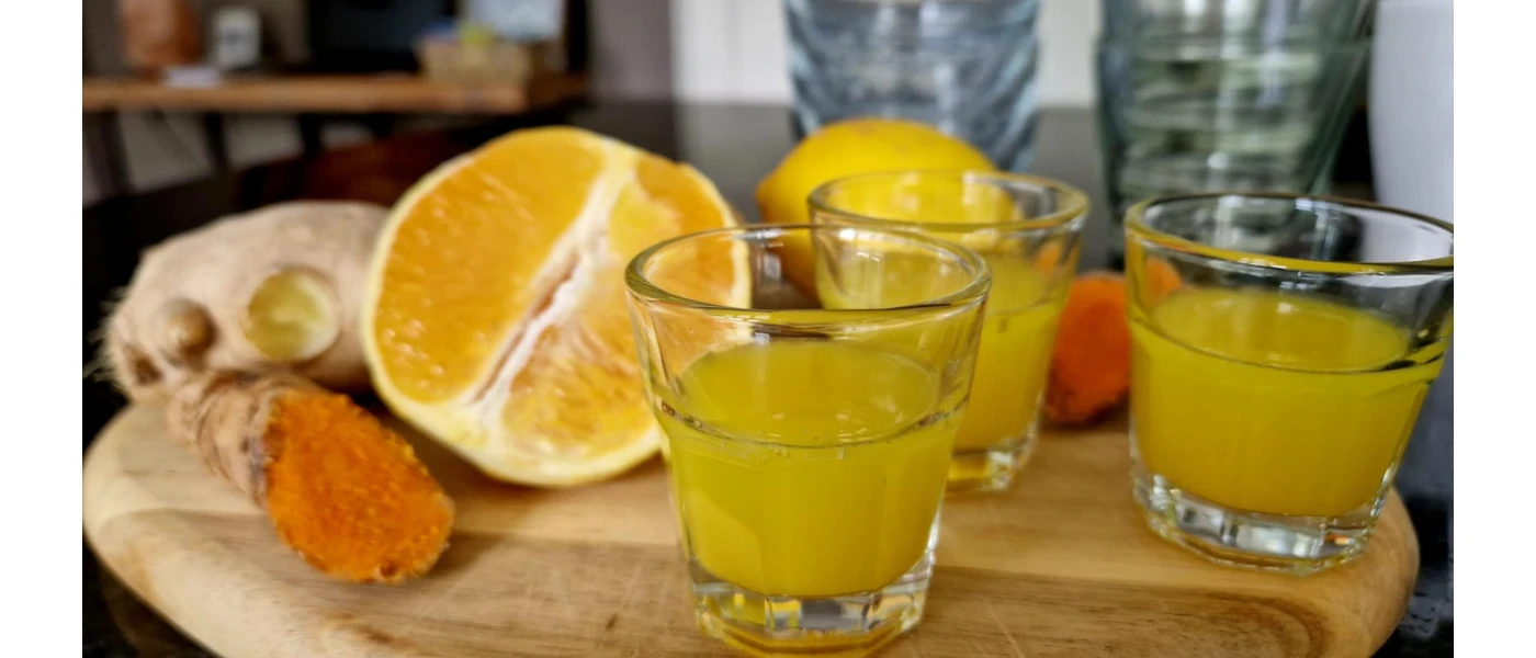 Glasses of juice next to lemons and ginger