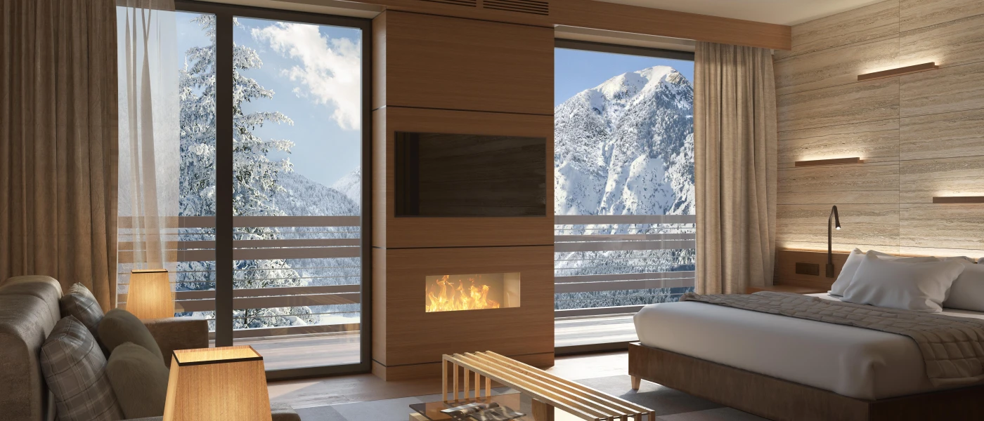 Hotel room with wood-panelled walls, a glass and wood coffee table, flatscreen TV, bed with white bedding and a plush neutral sofa