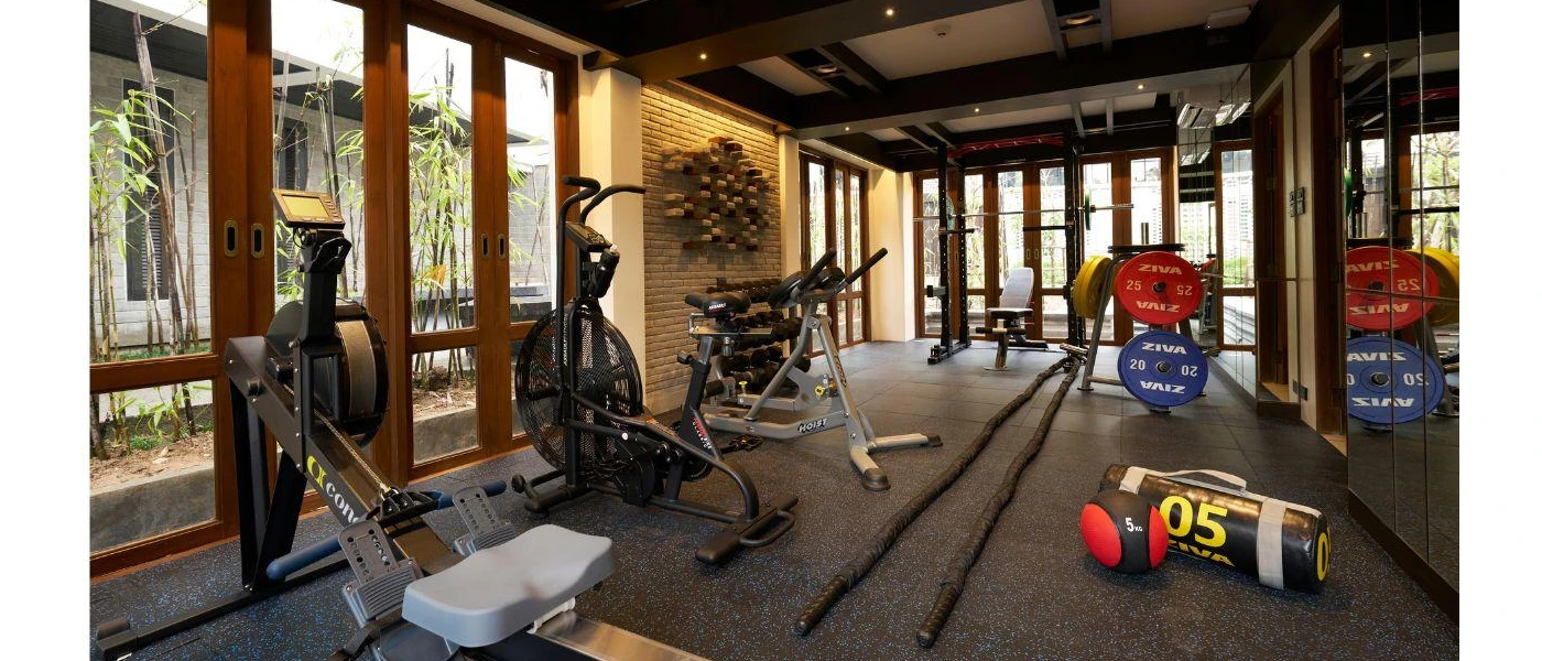 Gym with floor-to-ceiling windows equipped with a bike, rower and weightss