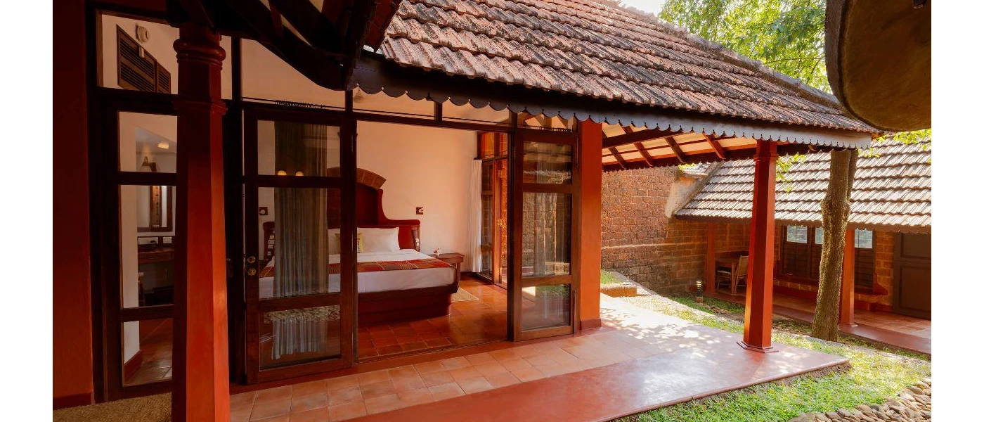 Villa with a wooden decking and garden, and a bedroom with a dark-wood headboard and crisp white bedding