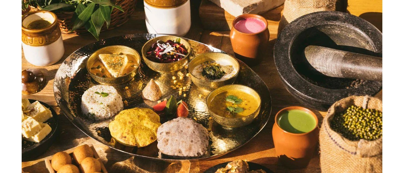 Silver platter with mounds of rice, bowls of yellow curry, salad and naan bread