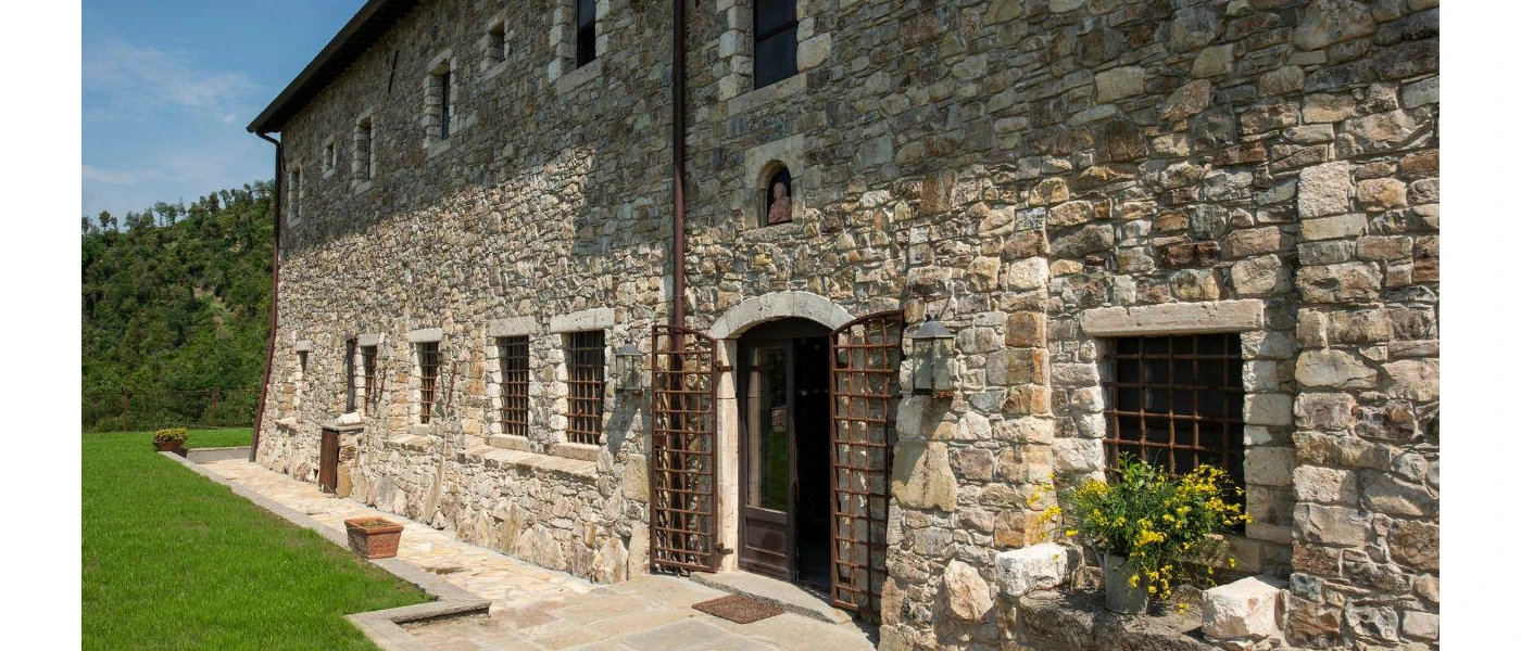 Cobbled-stone building fronted by a grassy lawn