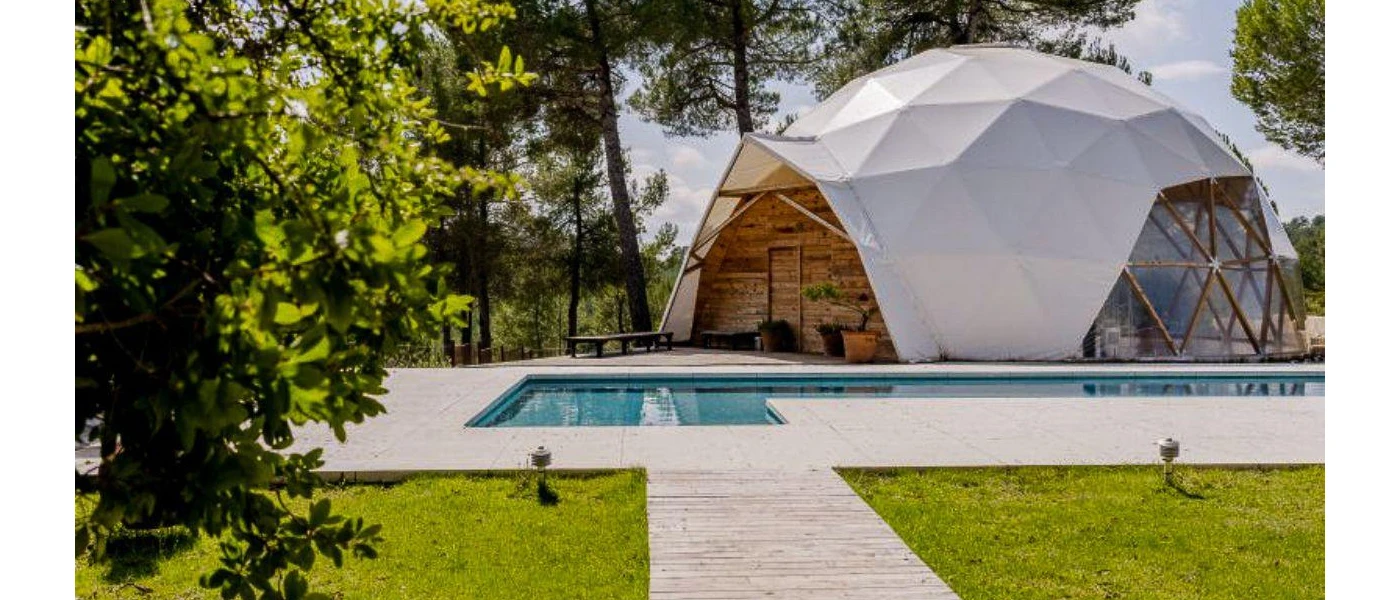Outdoor garden with a swimming pool with a domed structure with clear windows and a white covering