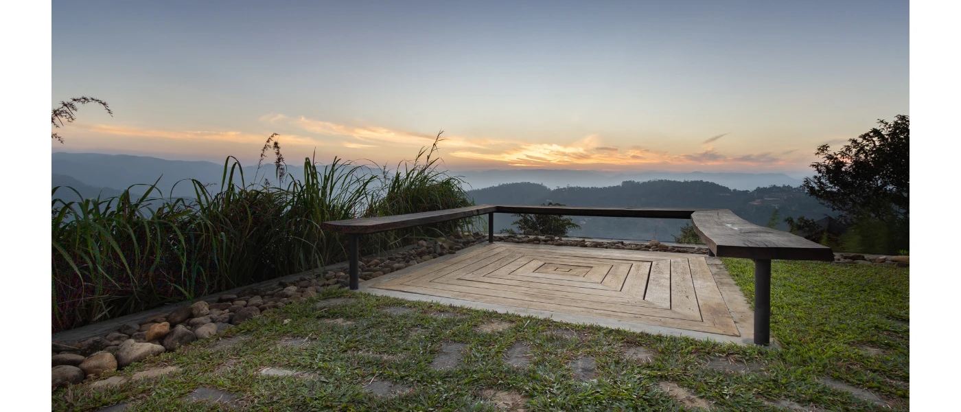 Stone terrace in a garden with views over hills at sunset