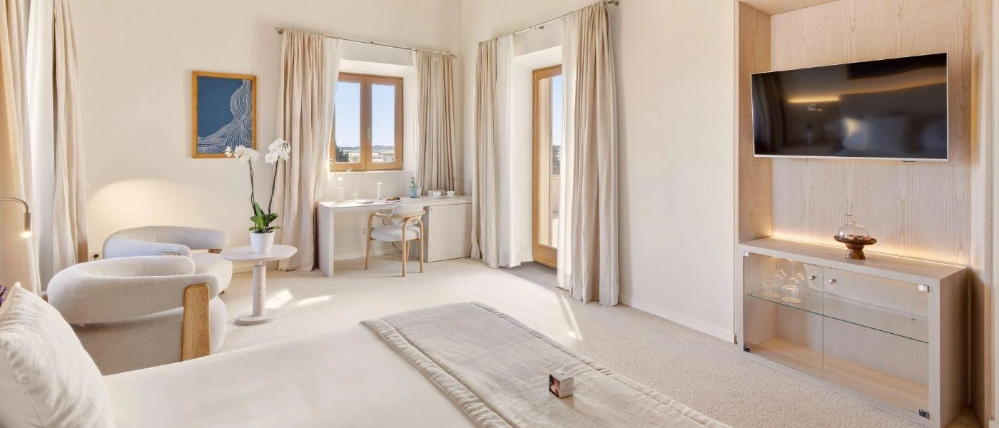 Neutral bedroom with wooden beams and a TV