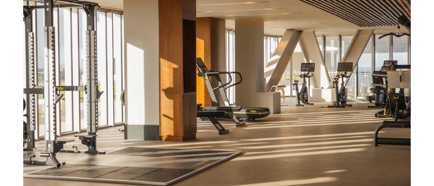 Gym with bikes, a weight machine and rower, and floor-to-ceiling windows