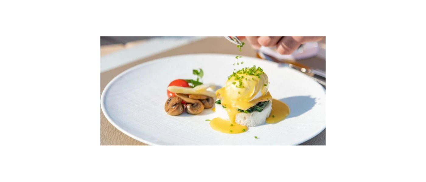 White plate with a bed of mushrooms and tomato, rice and a poached egg in a mustard-colour sauce