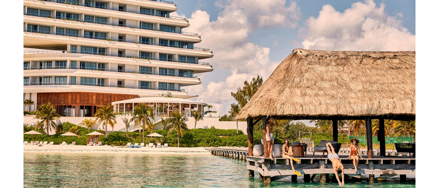 Corner of SHA Mexico, a white, multi-storey resort building on a white-sand beach, with a diving pavilion out in front