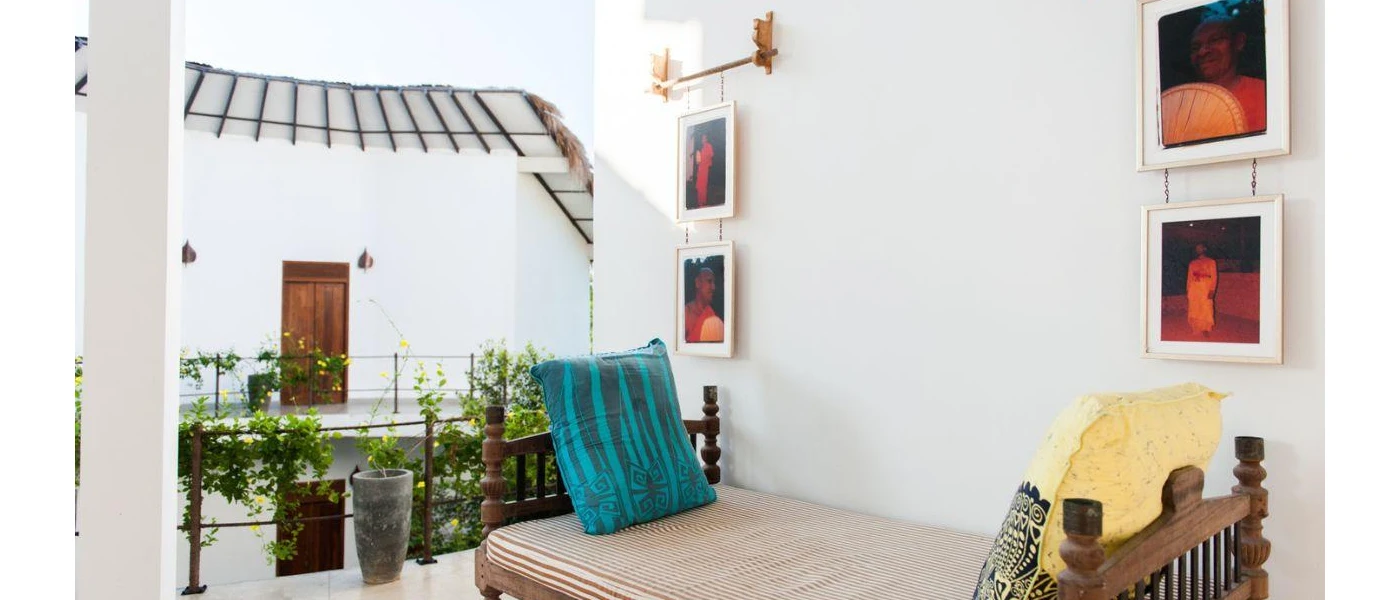Balcony with a cushioned sofa, and paintings depicting Sri Lankan people