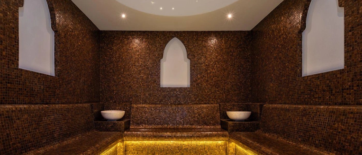 Dark tiled steam bath with Arabic-style archways