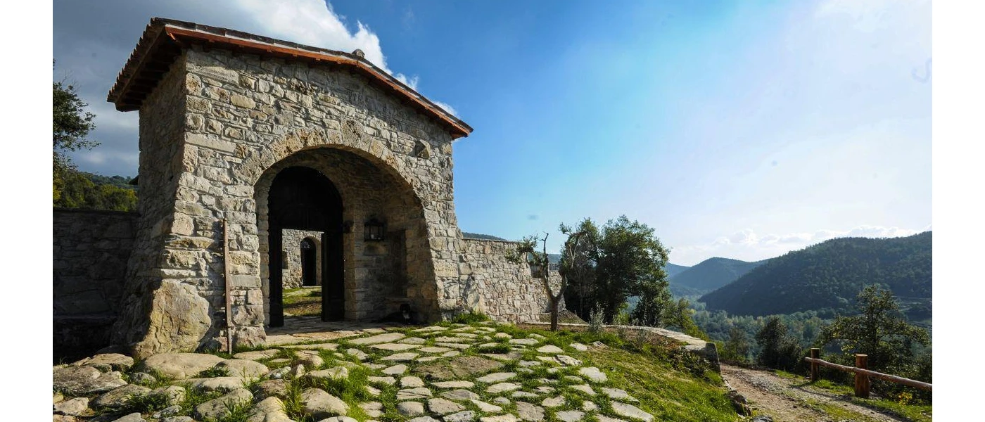 Stone archway on a hilltop surrounded by rolling green hills