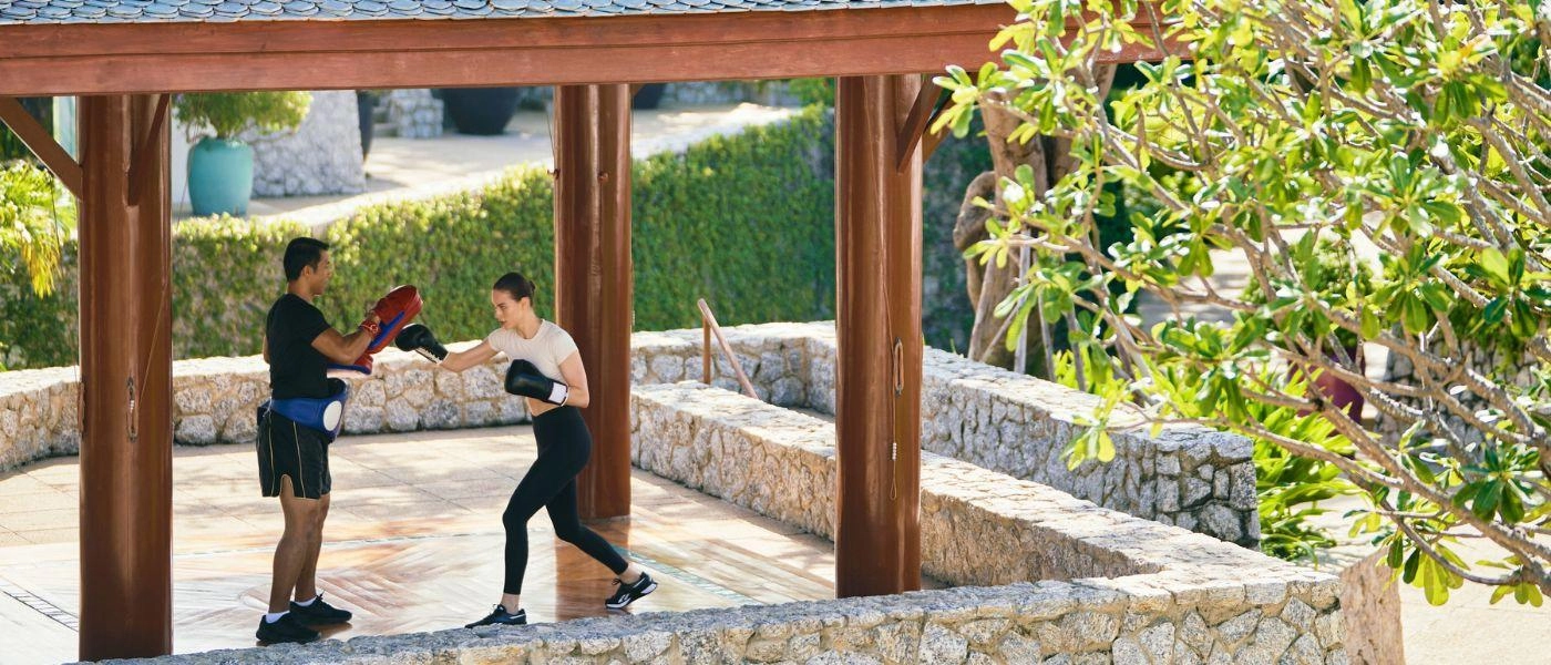 Lady is having a boxing class with a personal training on outdoor platform