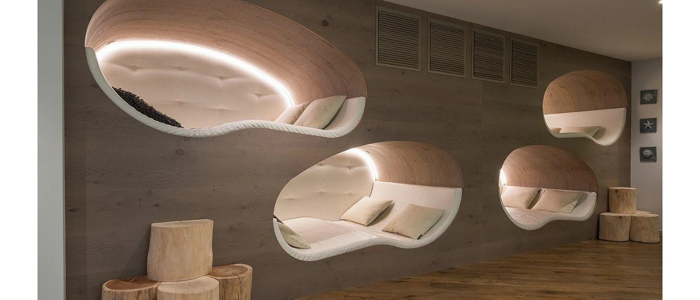 Wooden wall with cut-out spaces with white-cushioned beds
