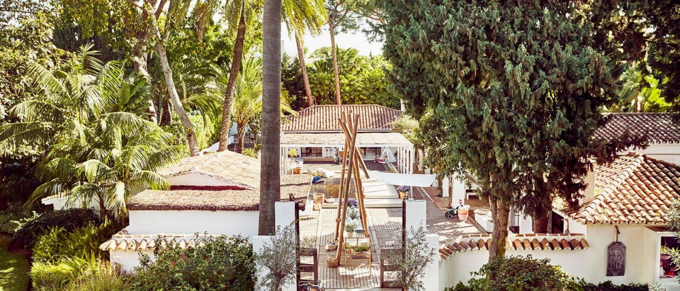 Central hotel courtyard with surrounding greenery, whitewashed buildings and terracotta rooftops