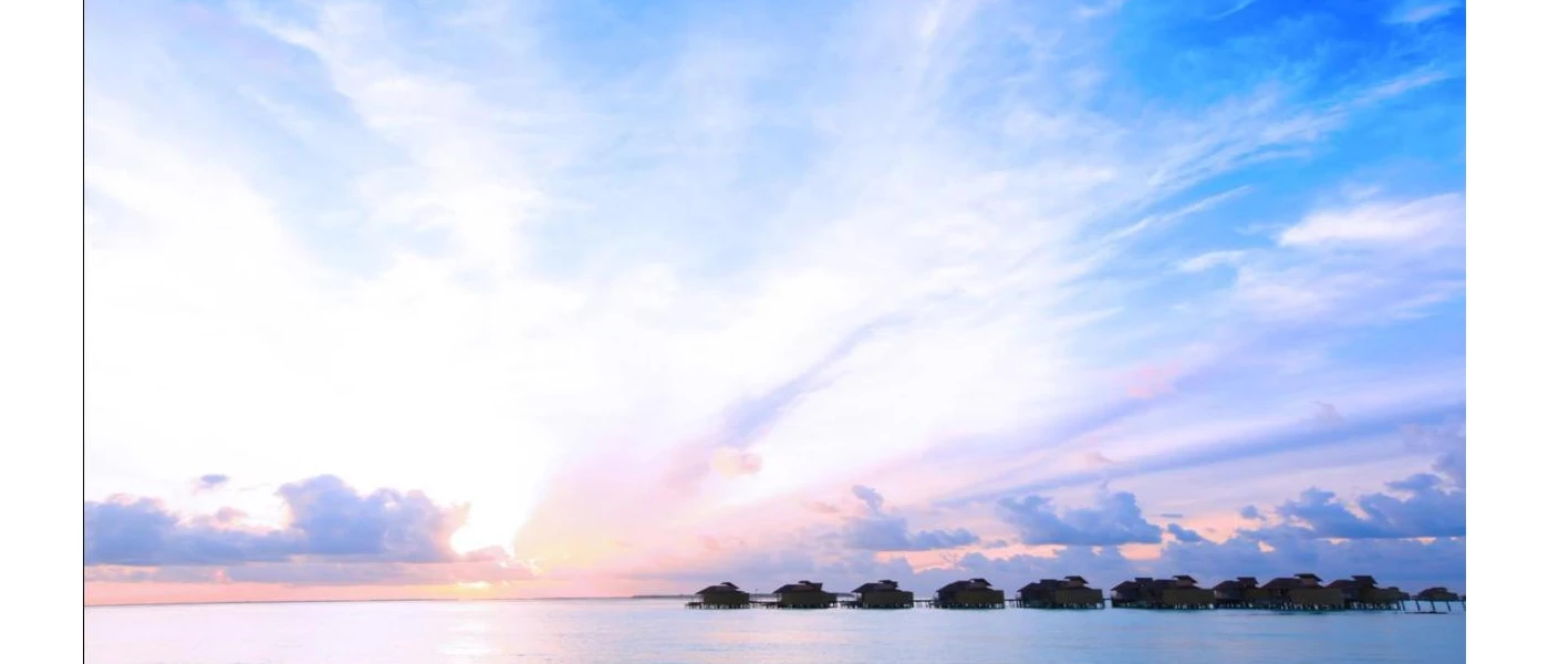 Silhouette of overwater villas as the sun goes down