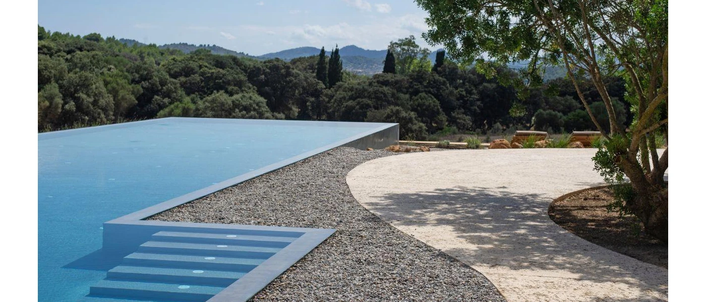 Outdoor swimming pool with steps and an infinity edge, with a view of the surrounding countryside