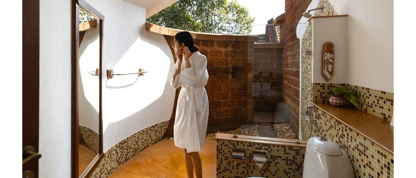 A female guest preparing in her outdoor bathroom featuring shower and toiler