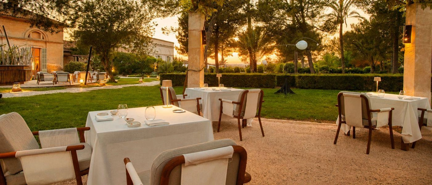 Garden dining terrace with tables and a grassy lawn to one side
