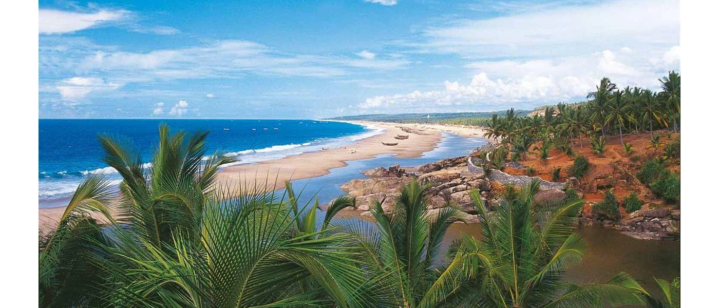Tropical greenery on hillsides overlooking a golden beach and the ocean