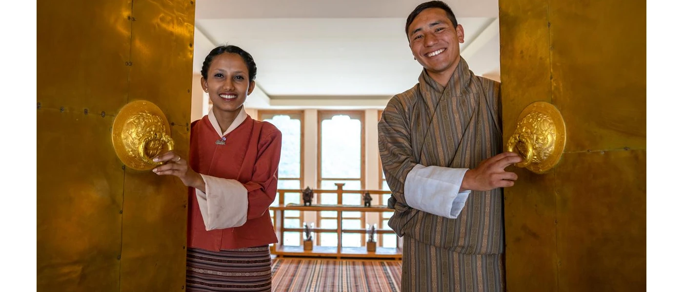 Smiling, robed staff opening double doors