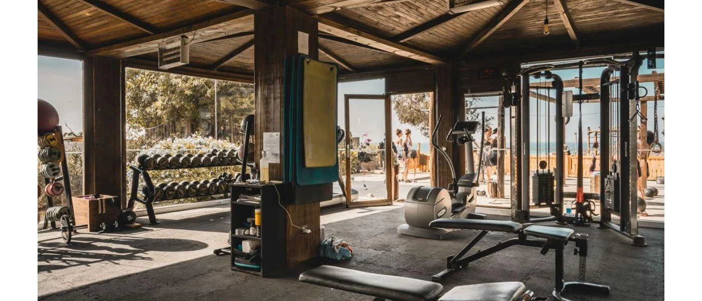 Well-equipped gym with open-air sides and a beach view