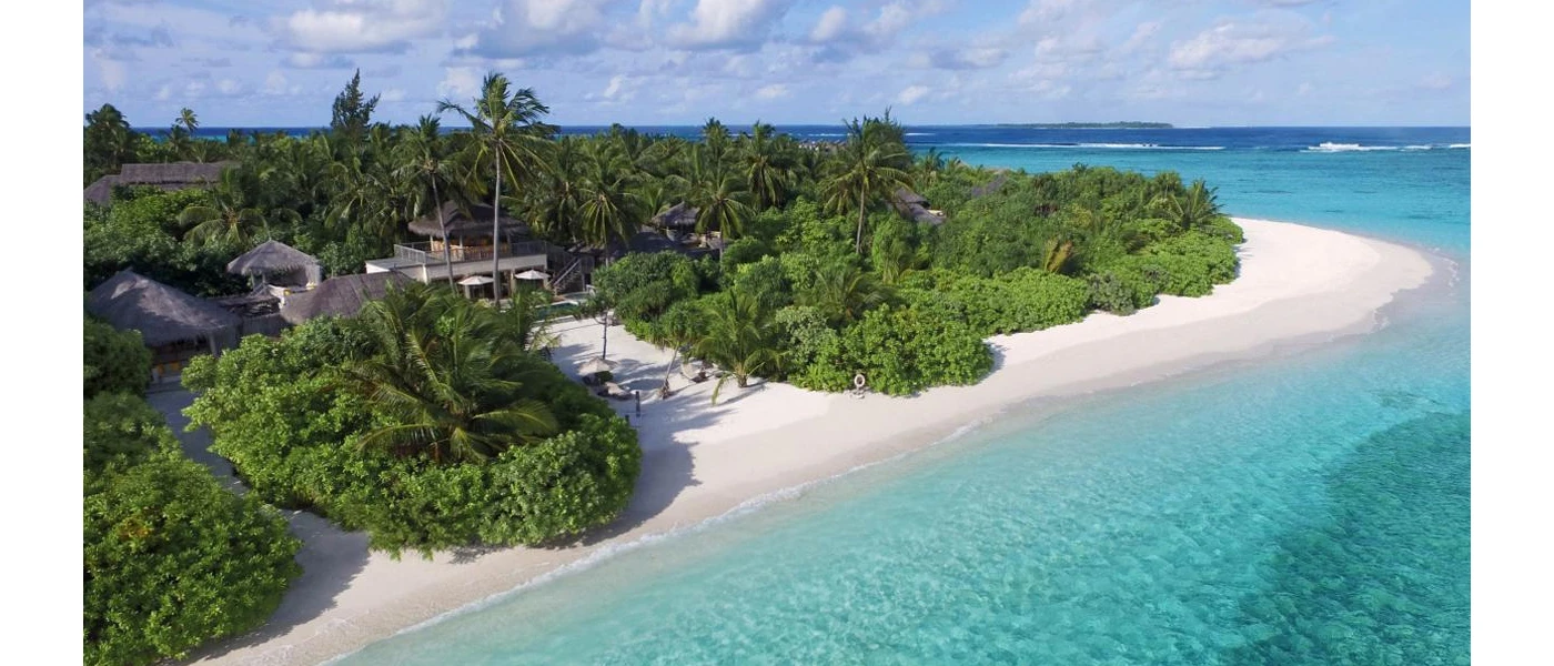 Tropical jungle-cloaked island with bright white sands and turquoise shallows