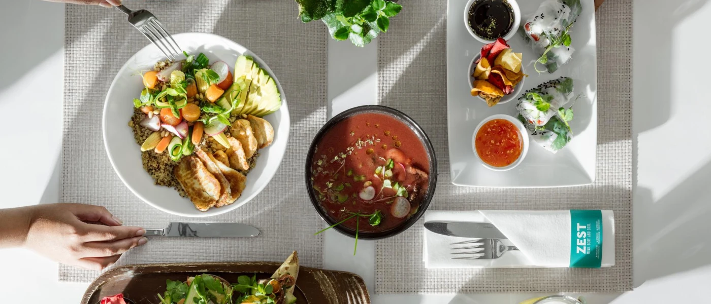 White table and plates laid up with fresh seafood, sauces and vegetables