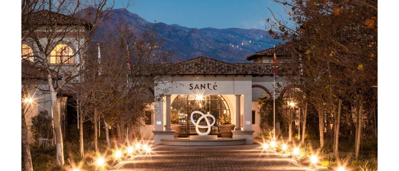 SANté Wellness Retreat & Spa entrance after dark, with a pathway lit but lights and a white exterior with the word 'SANté' written on the front