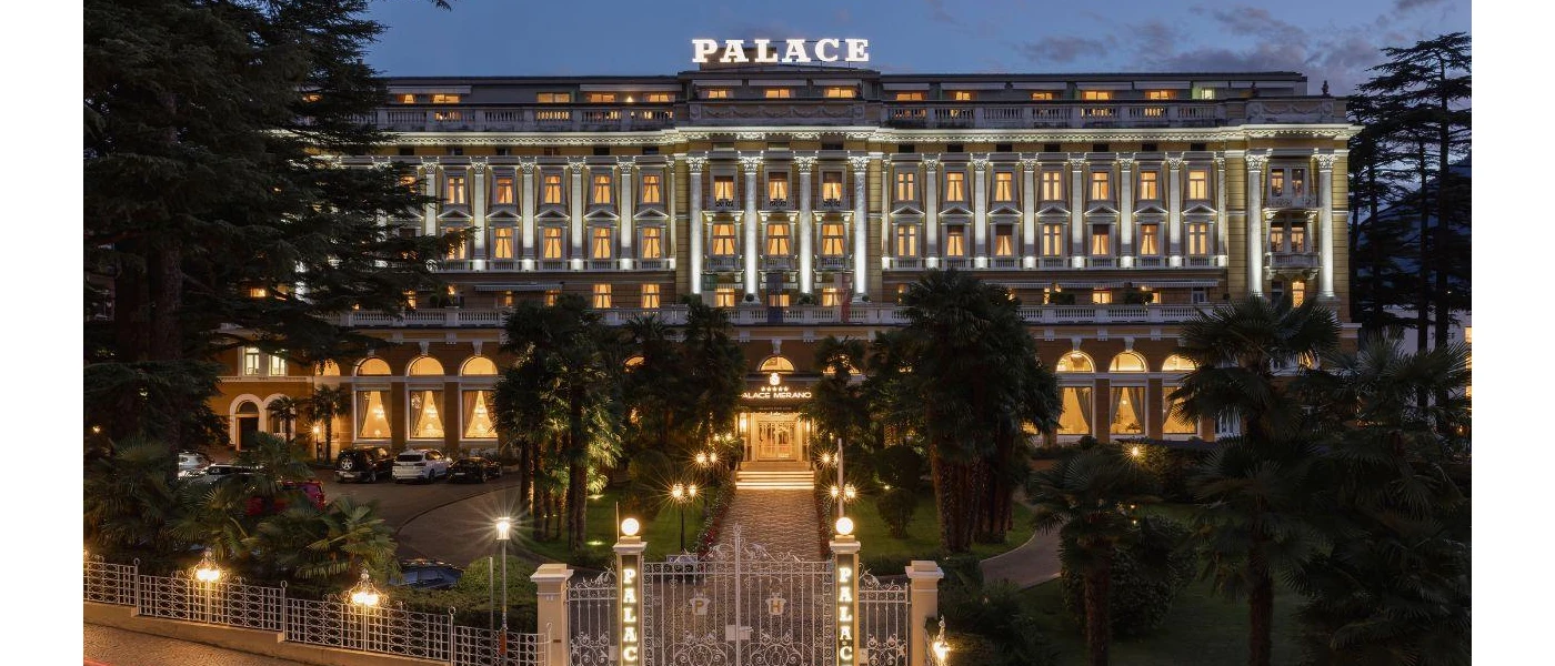 Exterior of Palace Merano at night featuring the front of the buiding and its gardens