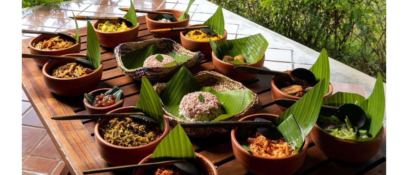 Brown bowls laid out on a table, with bamboo leafs inside topped with rice mounds, vegetables and lentils