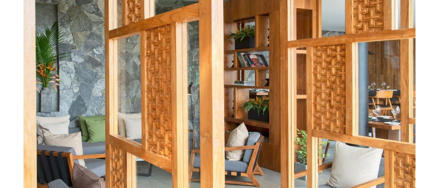 Reading nook with cushioned chairs, a shelf with books on and stone wall surrounds