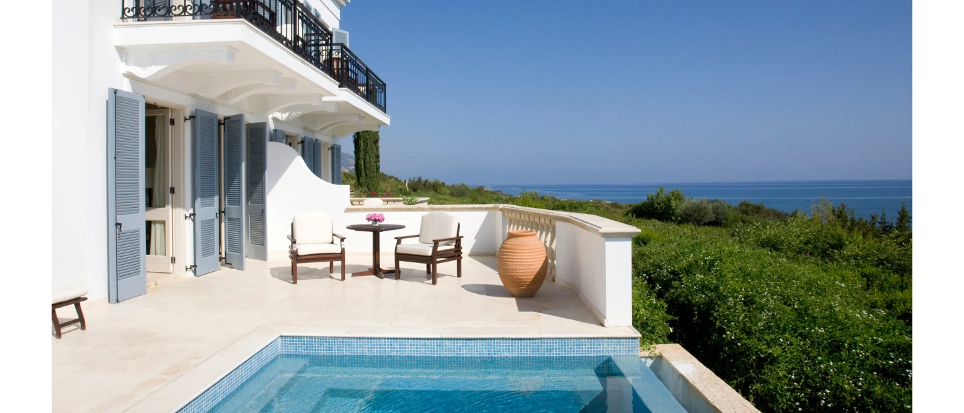 Sunny terrace with a small pool, a dark-wood table and chairs and a terracotta plant pot