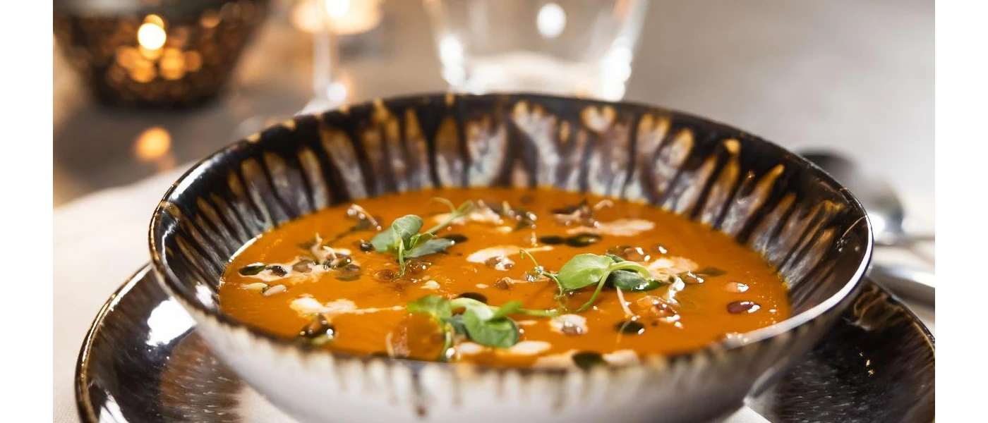 Butternut squash or pumpkin soup in a bowl garnished with herbs and yoghurt