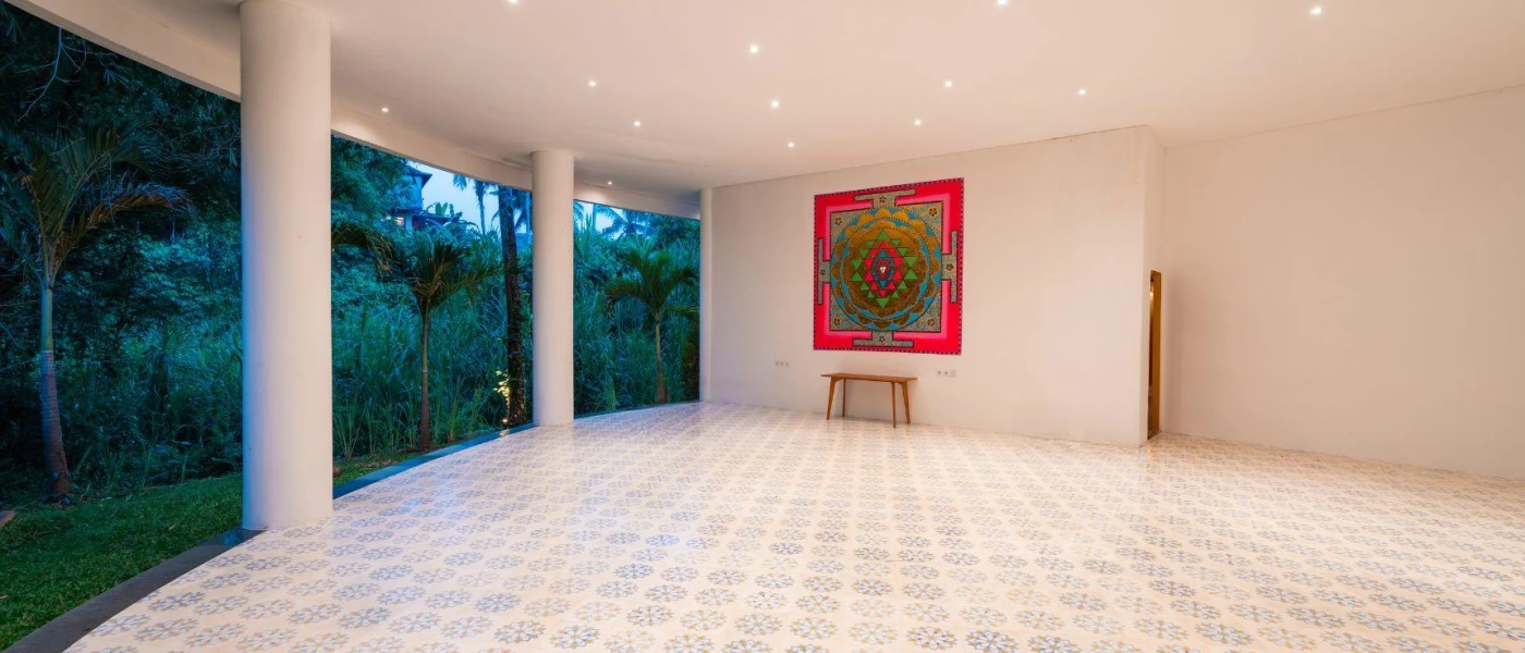 Empty room with spotlights in the ceiling, a white tiled floor and pink and blue wall art