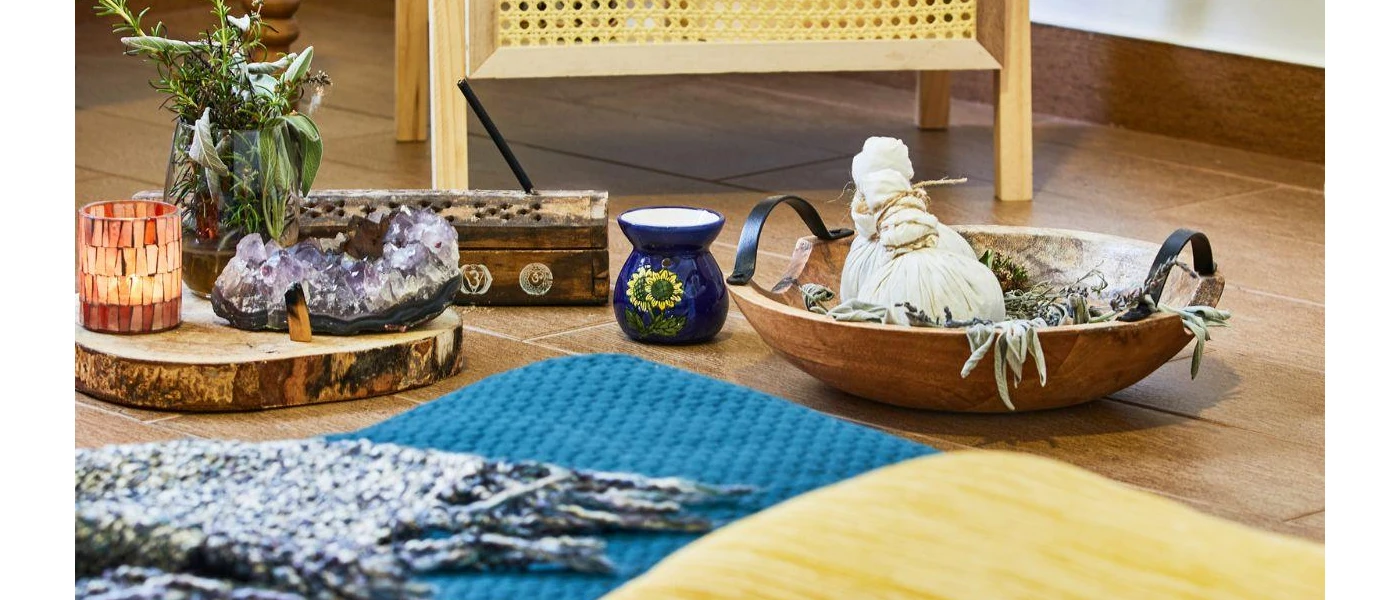 Incense bowls and sticks laid out next to a blue mattress and yellow throw