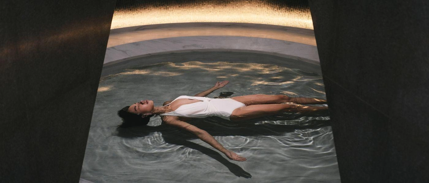 Lady in white swimsuit floats in the pool
